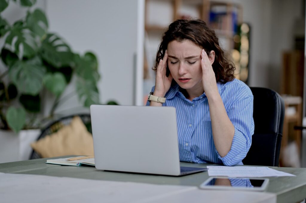 Woman struggling with a migraine at work