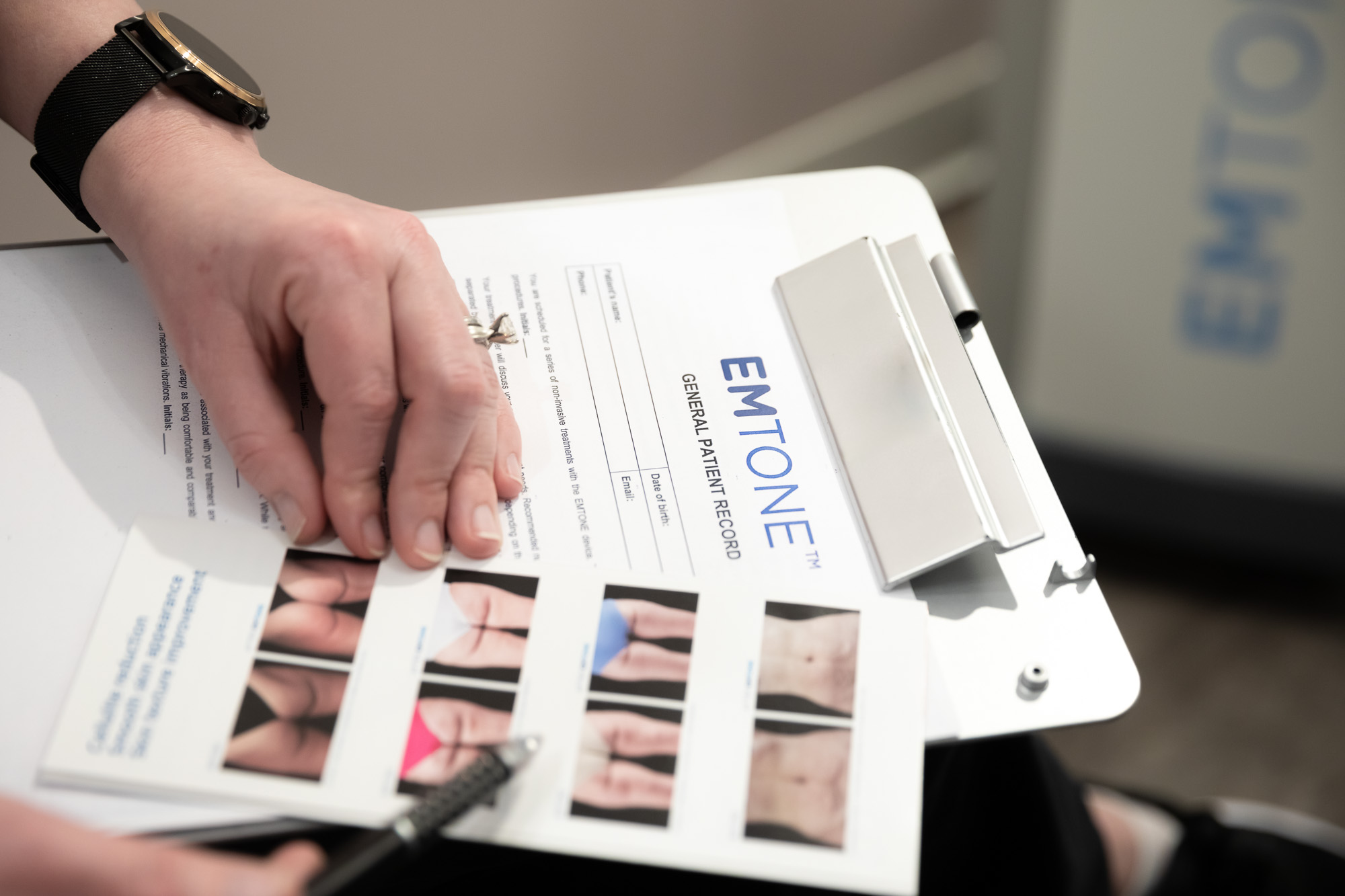 Close up of a person handling an Emtone treatment broshure, which is a body sculpting treatment available at The Longevity Lab in Denver